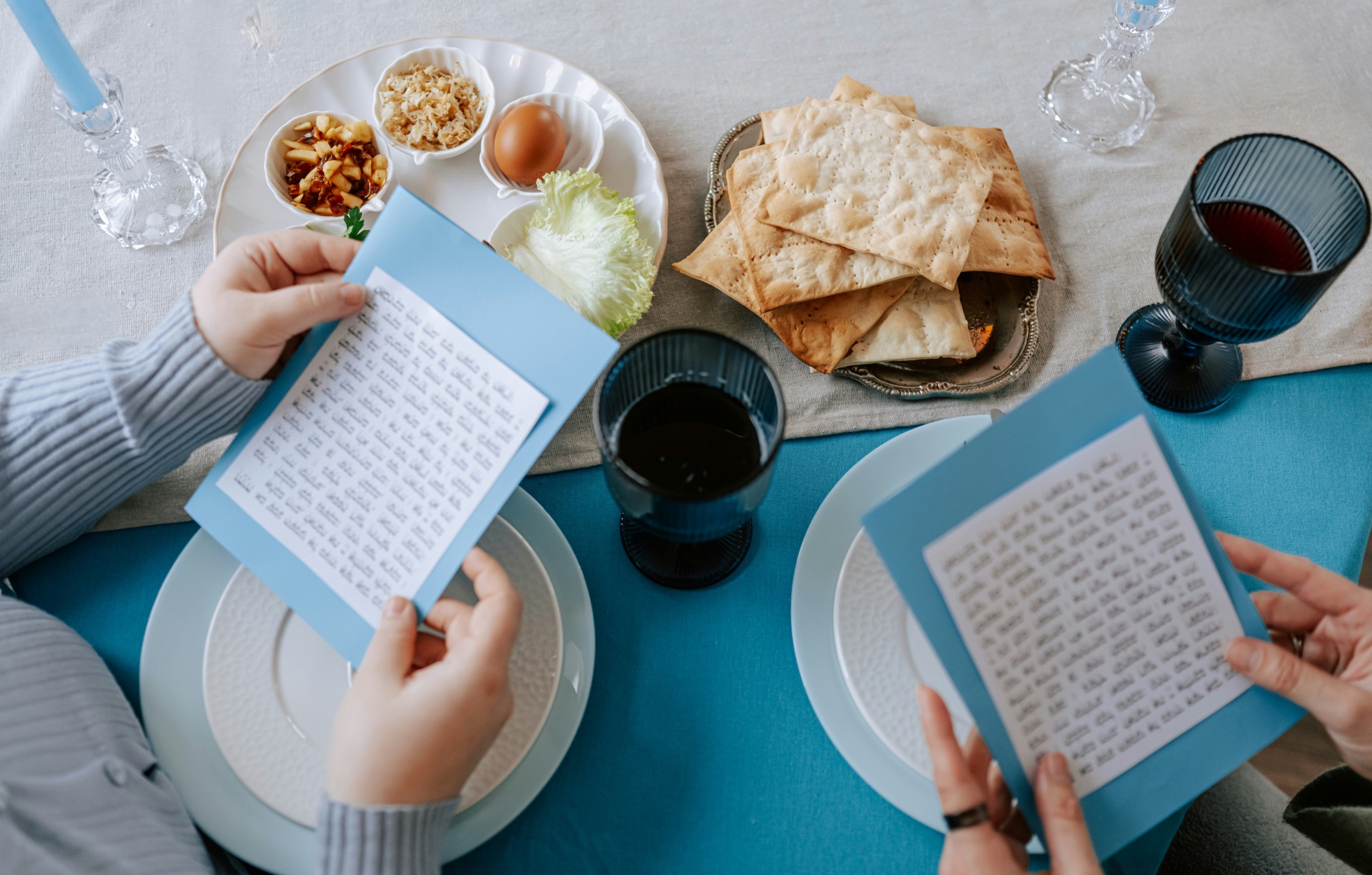 People reading menus at a table with flatbread and shared dishes