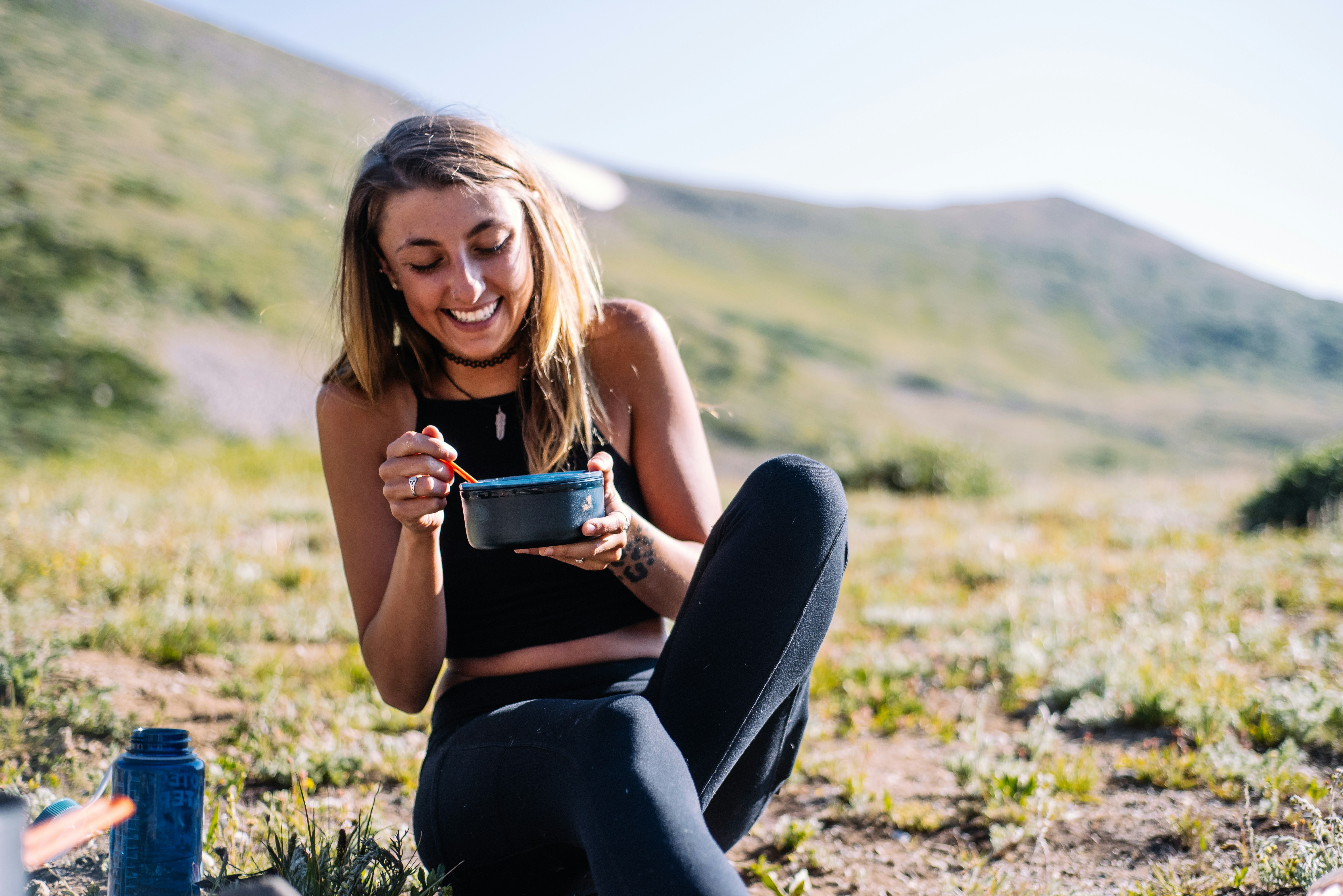 Woman eating outdoors in a sunlit field